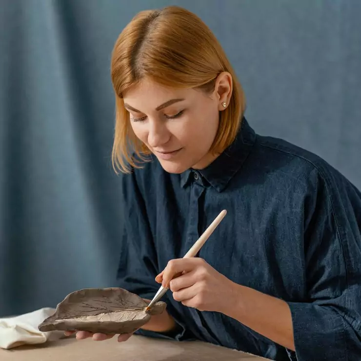 medium-shot-woman-painting-leaf